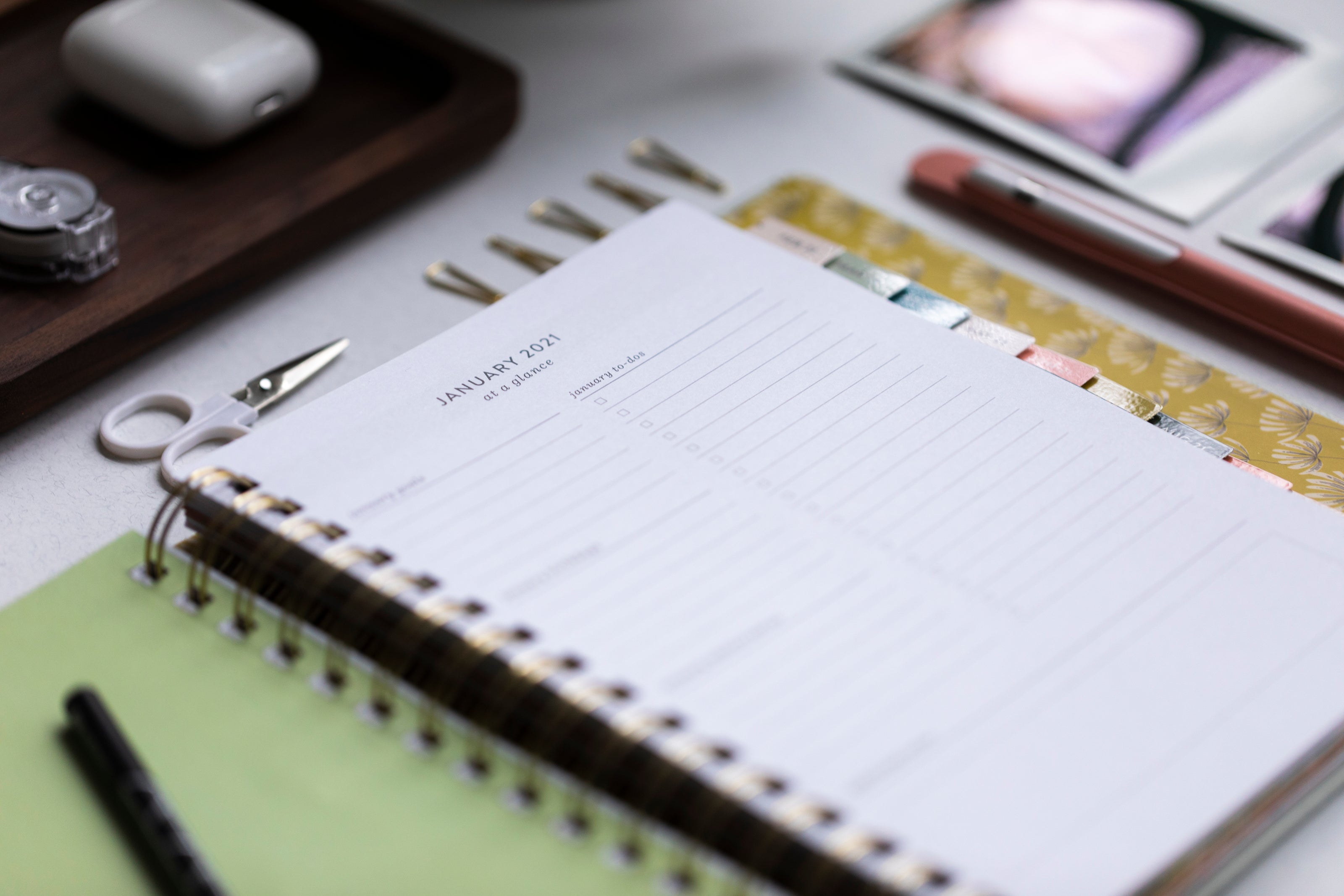 spiral bound calendar and pen sitting on a desk